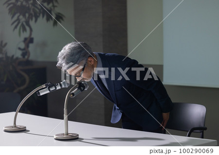 謝罪会見風のグレイヘアの男性 100290069