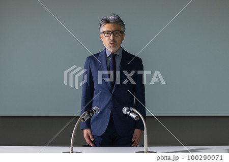謝罪会見風のグレイヘアの男性 100290071
