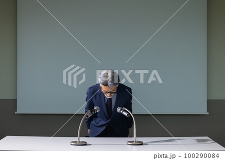 謝罪会見風のグレイヘアの男性 100290084