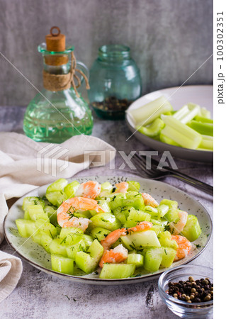 Fresh salad of celery and shrimp on a plate for a vegetarian diet vertical view Fresh salad of celery and shrimp on a plate for a vegetarian diet vertical view 100302351