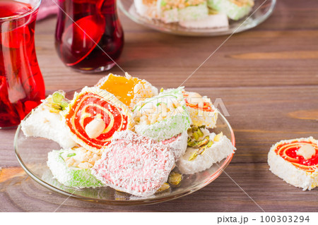 Traditional Turkish Delight. on a saucer and karkade in cups on a wooden table 100303294