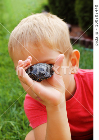 Little boy has fun with the turtle. 100303440