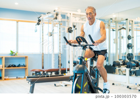 スポーツジムでエアロバイクをするミドル男性 スポーツジムでエアロバイクをするミドル男性 100303570