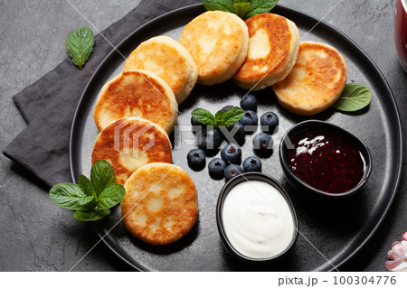 Cottage pancakes with jam, sour cream and berries 100304776