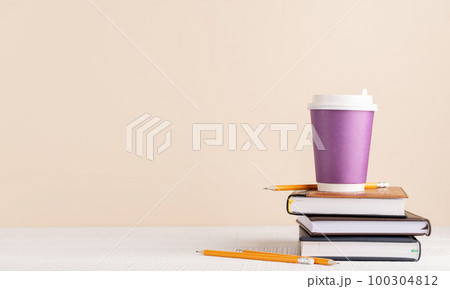Coffee cup on stack of notepads Coffee cup on stack of notepads 100304812