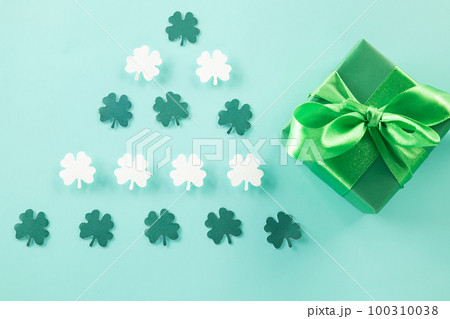 Happy St Patricks Day decoration background concept. shamrocks leaves holiday symbol with copy space on pastel background, above view gift box green clover leaves Happy St Patricks Day decoration background concept. shamrocks leaves holiday symbol with copy space on pastel background, above view gift box green clover leaves 100310038