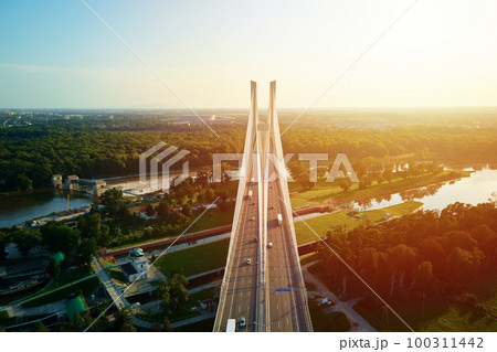 Aerial drone view of Redzinski bridge over Odra river in Wroclaw city, Poland. Large cable stayed bridge with car traffic in european city, bird eye view. Transportation infrastructure and logistic Aerial drone view of Redzinski bridge over Odra river in Wroclaw city, Poland. Large cable stayed bridge with car traffic in european city, bird eye view. Transportation infrastructure and logistic 100311442