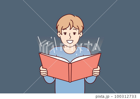 Boy before adolescence with open book in hands reads fairy tale or comics with interest 100312733