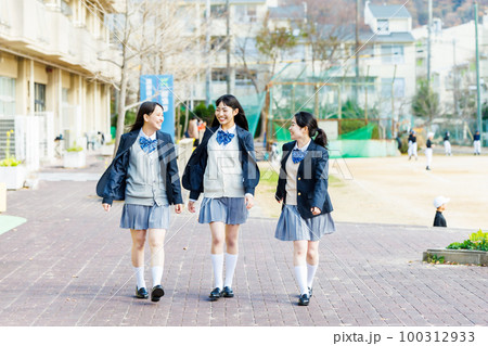 校内を友達と仲良く話しながら歩く女子高生 100312933