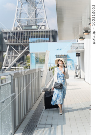 スーツケースを引いて名古屋観光をする若い女性 100313053