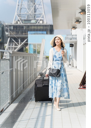 スーツケースを引いて名古屋観光をする若い女性 100313059