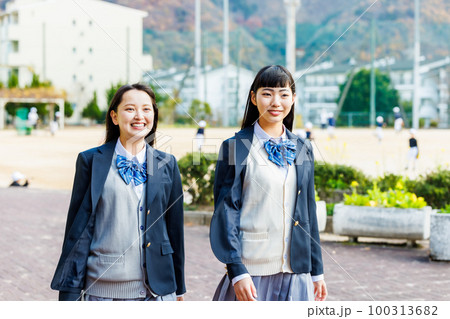 校内を友達と仲良く話しながら歩く女子高生 100313682