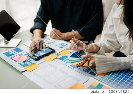 UI developer team brainstorming on their project with laptop, smartphone and digital tablet. Creative digital development agency.. UI developer team brainstorming on their project with laptop, smartphone and digital tablet. Creative digital development agency.. 100314826