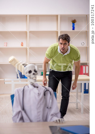 Young male patient visiting skeleton doctor 100317241