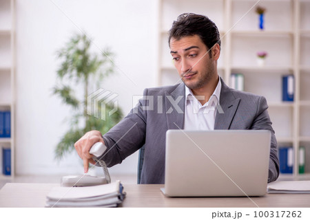 Young male employee and too much work in the office 100317262