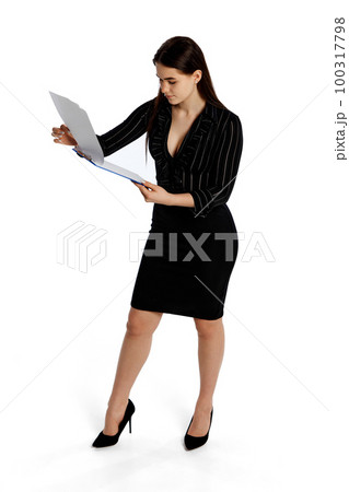 Young stylish girl, assistant and secretary reading paper contract isolated over white background. Model looks concentrated, serious Young stylish girl, assistant and secretary reading paper contract isolated over white background. Model looks concentrated, serious 100317798
