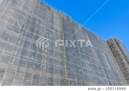 足場シートで囲まれた修繕工事中のマンション（修繕工事イメージ） 100318988