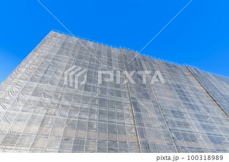 足場シートで囲まれた修繕工事中のマンション(修繕工事イメージ) 足場シートで囲まれた修繕工事中のマンション(修繕工事イメージ) 100318989