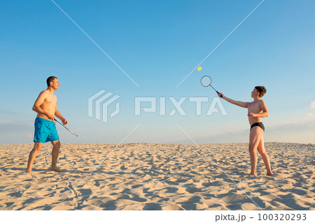 The family plays beach badminton. Sports, lifestyle. Family games in summer on vacation 100320293