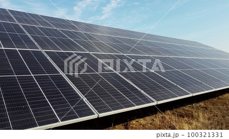 Solar power plant. Flight over modules of solar power station on sunny day. Renewable electrical energy. Alternative green electricity power. photovoltaic modules photobatteries. New modern technology Solar power plant. Flight over modules of solar power station on sunny day. Renewable electrical energy. Alternative green electricity power. photovoltaic modules photobatteries. New modern technology 100321331