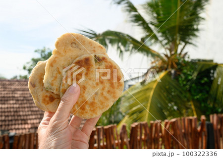 Authentic Sri Lankan three Pol Coconut Roti iin hand. 100322336