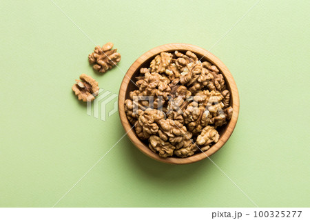 Fresh healthy walnuts in bowl on colored table background. Top view Healthy eating bertholletia concept. Super foods 100325277