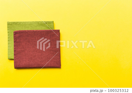 top view with red empty kitchen napkin isolated on table background. Folded cloth for mockup with copy space, Flat lay. Minimal style 100325312