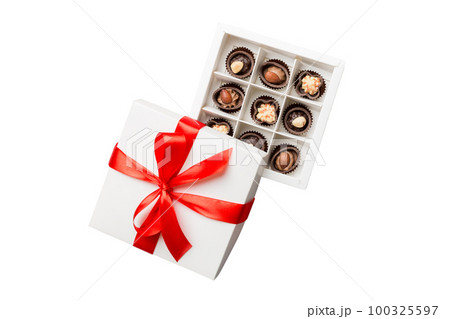 Chocolate candy in a box with a colored bow. Gift box with Chocolates isolated on white top view 100325597