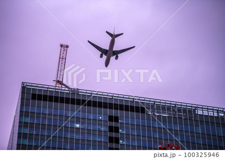 日本の東京都市景観 暗雲が広がる渋谷から桜丘口再開発のビル上空を通過する航空機。航空需要回復＝13日 100325946