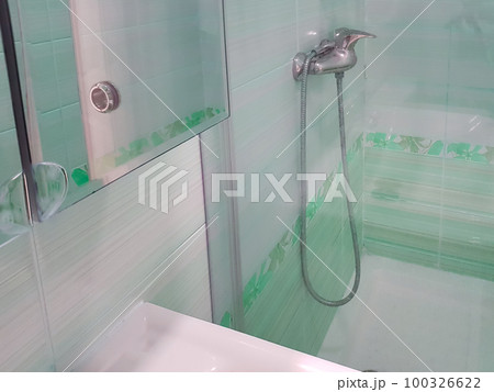 Bathroom with shower with glass partition, faucet in the background 100326622