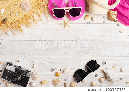 Camera straw hat sunglasses flip flops on white wooden background Camera straw hat sunglasses flip flops on white wooden background 100327575