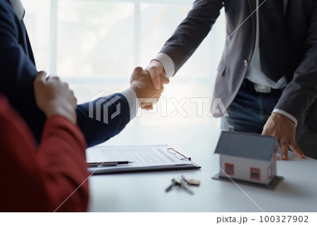 Asian real estate agent shaking hands handing over house and keys to his client's house after client sign contract Asian real estate agent shaking hands handing over house and keys to his client's house after client sign contract 100327902
