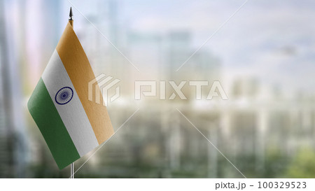 Small flags of the India on an abstract blurry background 100329523