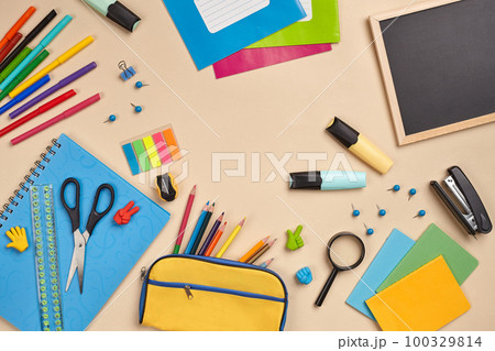 Flat lay photo of workspace desk with school accessories or office supplies on pink background. Flat lay photo of workspace desk with school accessories or office supplies on pink background. 100329814
