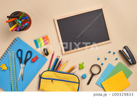 Flat lay photo of workspace desk with school accessories or office supplies on pink background. Flat lay photo of workspace desk with school accessories or office supplies on pink background. 100329833