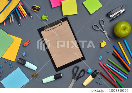 Flat lay photo of workspace desk with school accessories or office supplies on gray background. 100330092