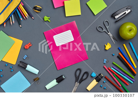 Flat lay photo of workspace desk with school accessories or office supplies on gray background. 100330107
