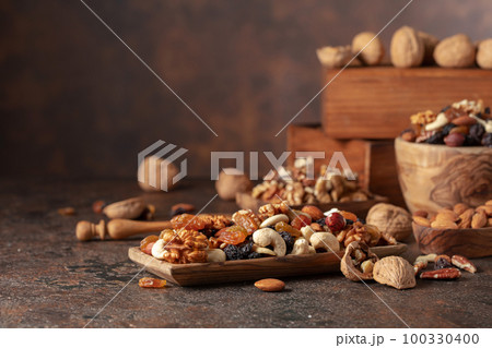 Mix of nuts and raisins on a brown rustic background. 100330400