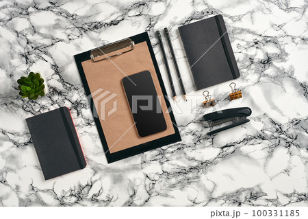 Top view in focus with different office equipment, supplies, stationery. Marble table with copy space. Education, workplace background. Close-up. 100331185