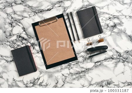 Top view in focus with different office equipment, supplies, stationery. Marble table with copy space. Education, workplace background. Close-up. 100331187