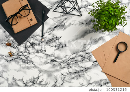 Top view in focus with different office equipment, supplies, stationery. Marble table with copy space. Education, workplace background. Close-up. 100331216