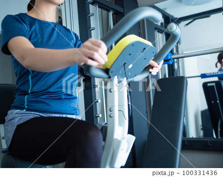 アップライトバイクでトレーニングする女性 100331436