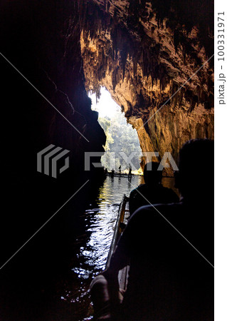 Tourists in silhouette ferried on bamboo rafts inside the tunnel river within Tham Nam Lod caves, Mae Hong Son province, Thailand. 100331971
