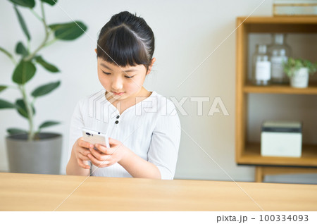 お家でスマホを操作する小学生の女の子 100334093