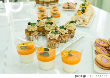 Candy bar for the holiday with muffin and cream, tangerine panna kota , desserts on the table Candy bar for the holiday with muffin and cream, tangerine panna kota , desserts on the table 100334622