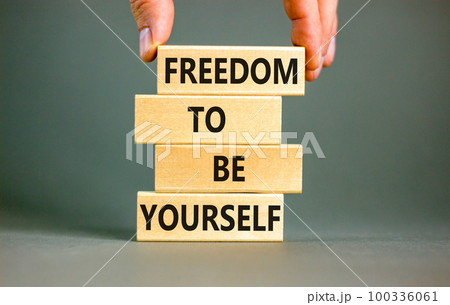 Freedom to be yourself symbol. Concept words Freedom to be yourself on wooden blocks on a beautiful grey background. Businessman hand. Business, psychological freedom to be yourself concept. Freedom to be yourself symbol. Concept words Freedom to be yourself on wooden blocks on a beautiful grey background. Businessman hand. Business, psychological freedom to be yourself concept. 100336061