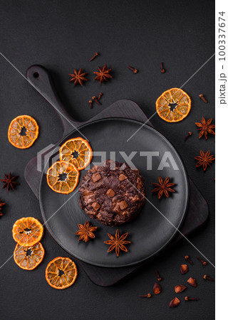 Delicious fresh oatmeal round cookies with chocolate on a black ceramic plate 100337674