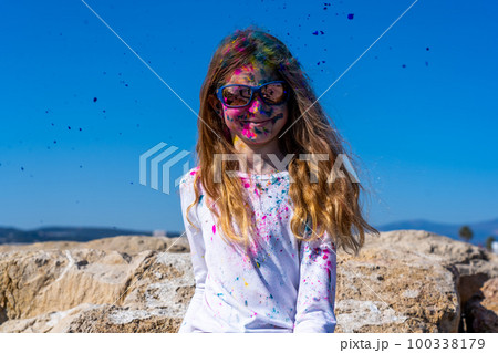 Young european girl celebrating holy festival on a blue sky background Young european girl celebrating holy festival on a blue sky background 100338179