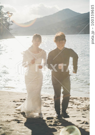 砂浜を走る新郎新婦 砂浜を走る新郎新婦 100339685