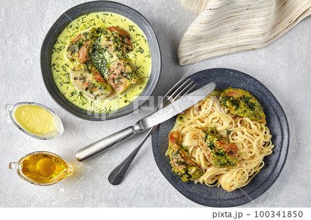 Grilled chicken breast pasta and gravy boats on a gray concrete table Grilled chicken breast pasta and gravy boats on a gray concrete table 100341850